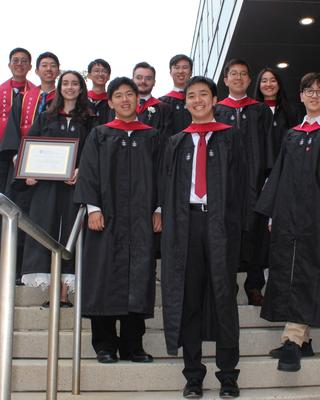 Master's students who graduated in 2025 posing on steps of the Science Center